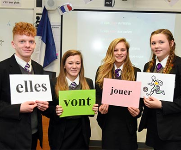 Students holding posters of french words
